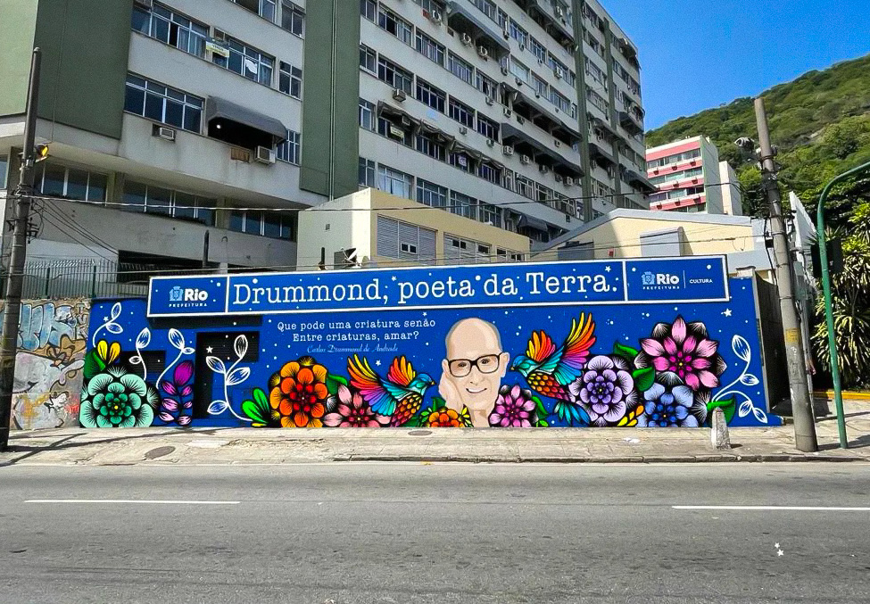 Espaço Cultural Sérgio Porto: muro com pintura de Carlos Drummon de Andrade e a frase: Drummond, Poeta da Terra