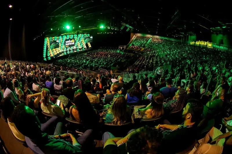 Foto mostra evento web summit rio com plateia lotada