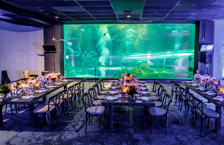 Foto mostra jantar no AquaRio com várias mesas e cadeiras