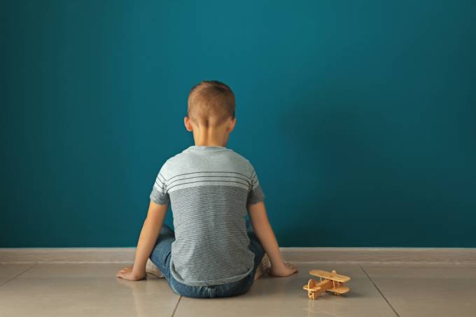Little,Boy,Sitting,Near,Dark,Wall,In,Empty,Room.,Autism