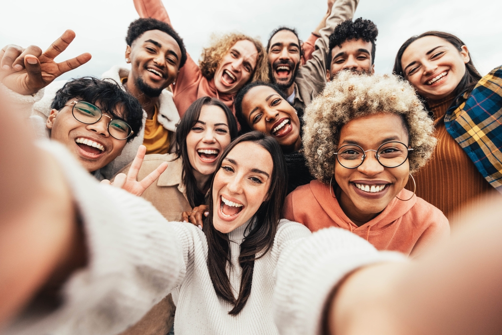 Grupo de jovens faz uma selfie sorrindo.