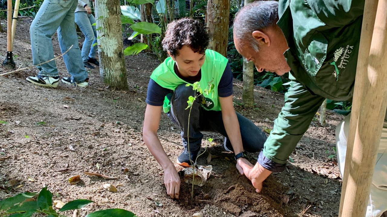 Foto voluntário plantando muda no aniversário de 62 anos do Parque Nacional da Tijuca.