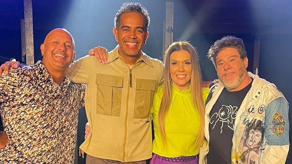 Mike (homem branco careca, com olhos castanhos, com camisa de botão estampada), Jairzinho (homem negro de pele clara com com olhos castanhos, de camisa bege), Simony (mulher branca com o cabelo louro e olhos castanhos) e Tob (homem branco, de olhos claros cabelo castanho clara e barba grisalha, com blusa preta e jaqueta clara).