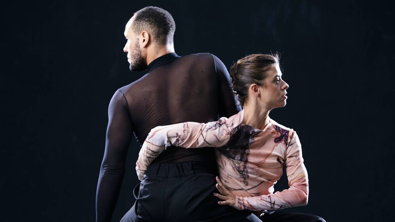 Homem com segunda pele preta transparente e mulher com segunda pele rosa fazendo coreografia de dança