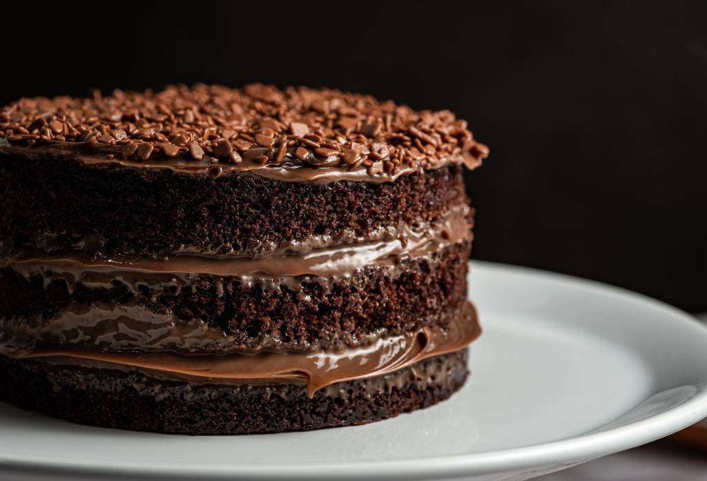 Foto de bolo de chocolate com dois recheios de brigadeiro com cobertura de granulados de chocolate belga