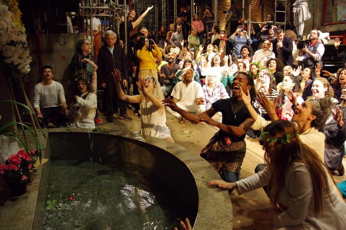 Atores do Teatro Oficina, ajoelhados, cantam em homenagem a Zé Celso.