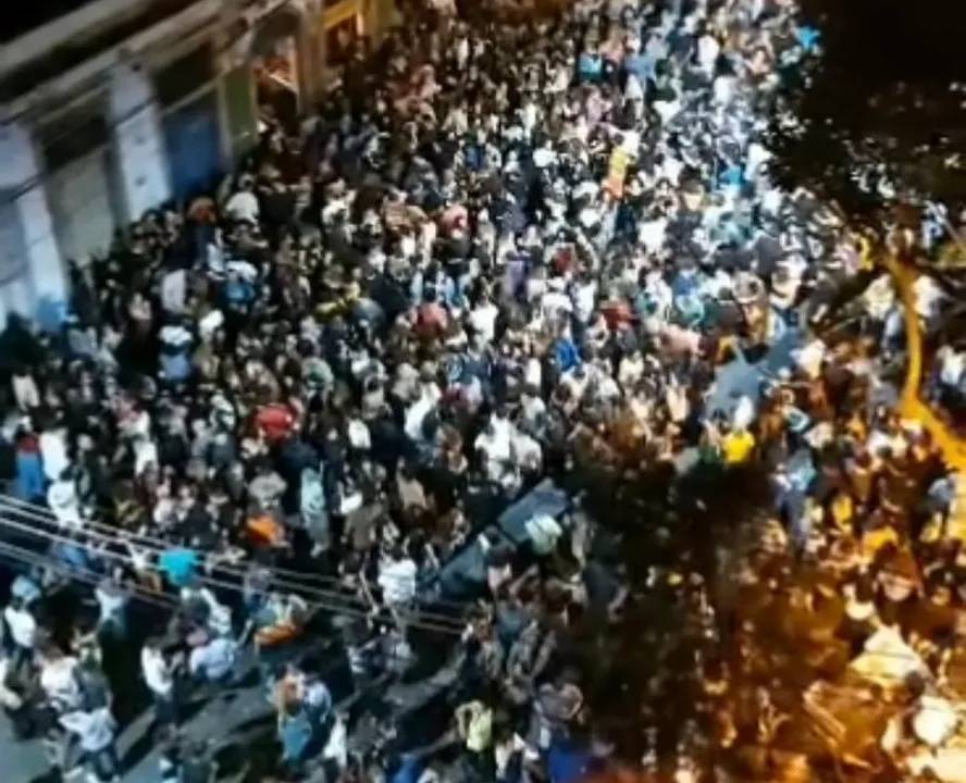 Frame de um vídeo com uma multidão se espalhando pelas ruas vista de cima