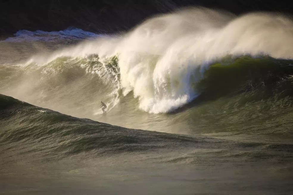 Foto mostra onda grande sendo surfada
