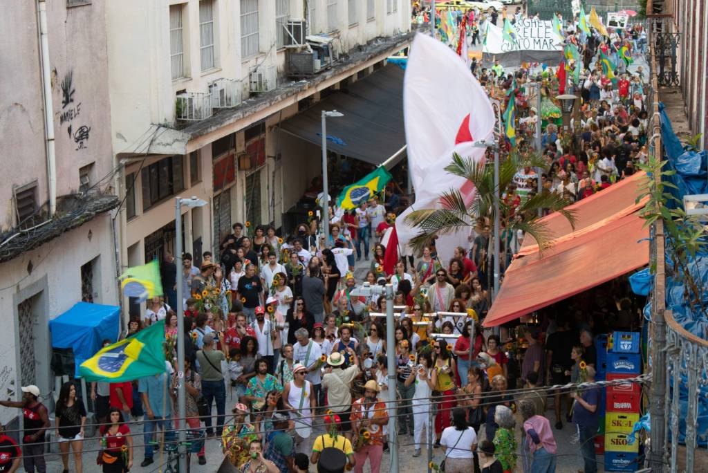 O cortejo Parada 7, com artistas caminhando na rua fotografados de cima
