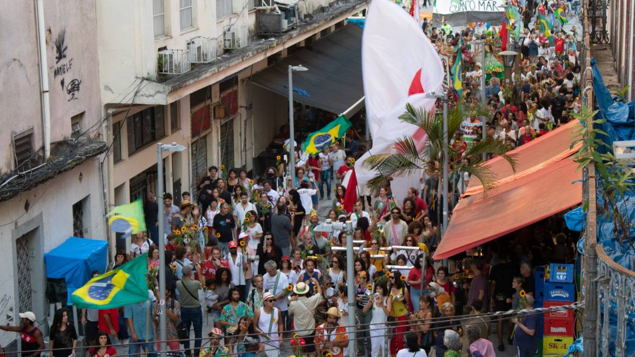 O cortejo Parada 7, com artistas caminhando na rua fotografados de cima