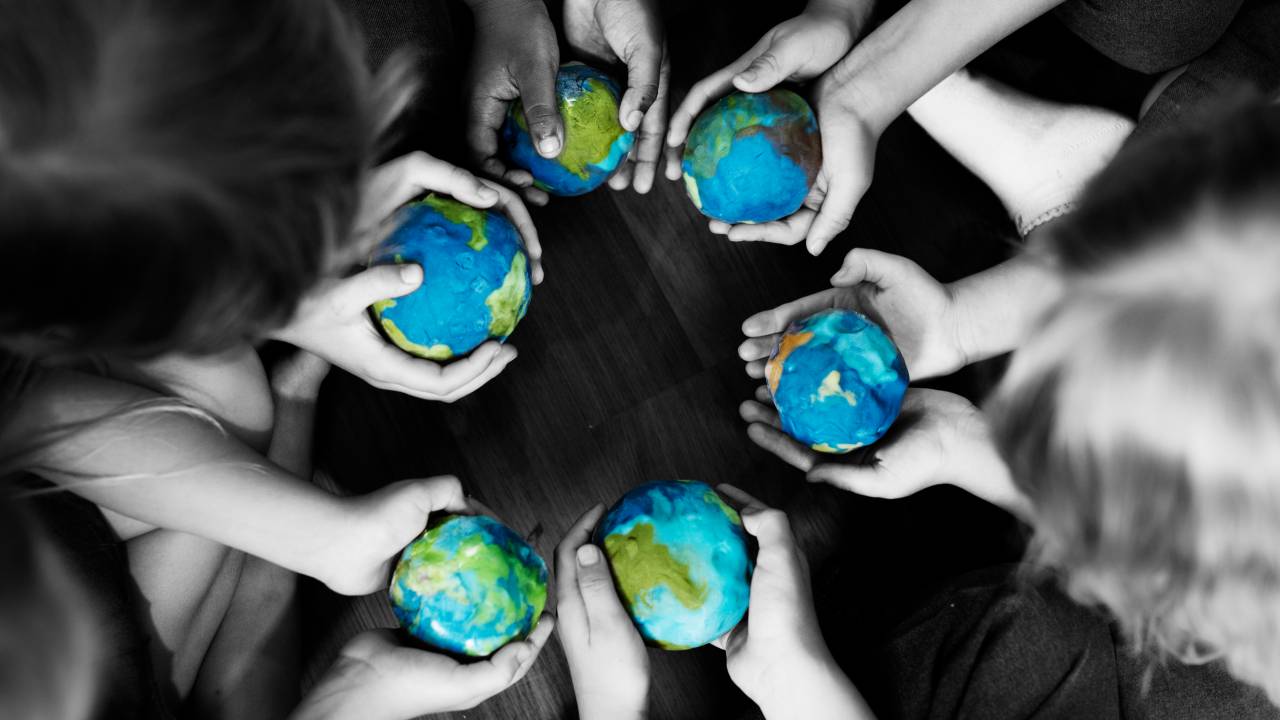 mãos infantis carregam globos terrestres