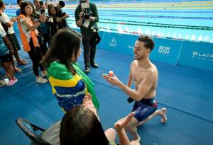 Nadador ajoelha-se, pedindo a namorada em casamento