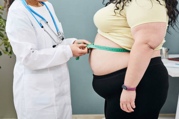 Profissional de saúde mede a cintura de uma pessoa obesa.