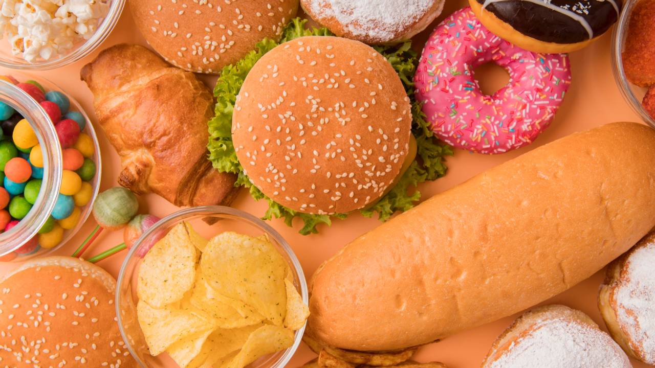 Diversos alimentos ultraprocessados sobre uma mesa.