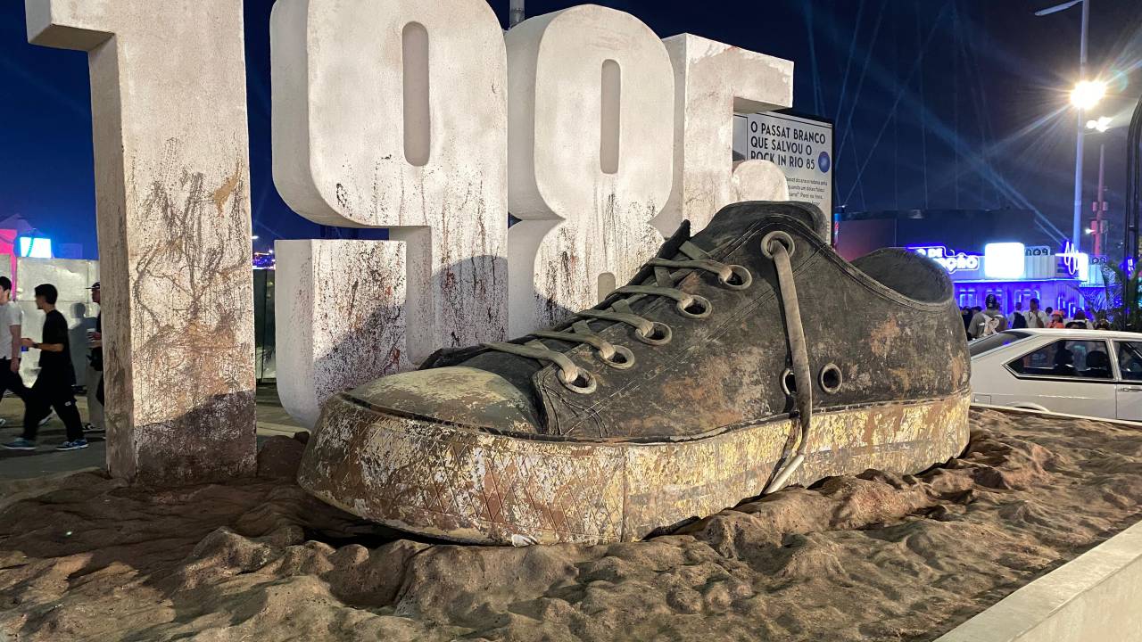 Letreiro "1985": tênis gigante de lama