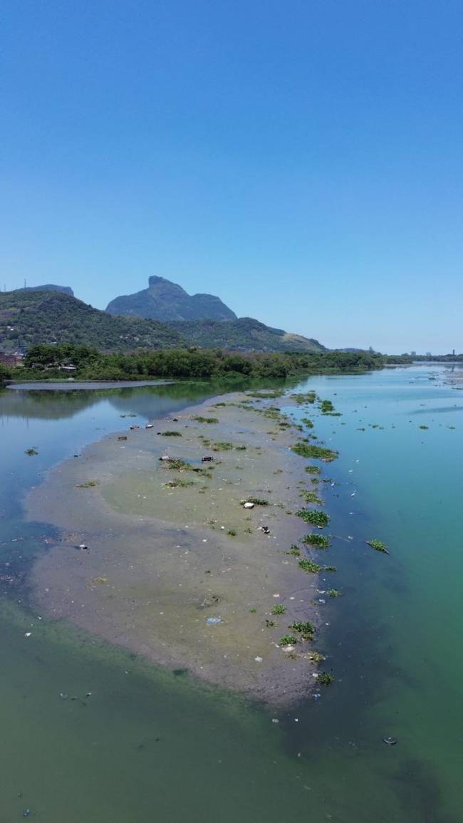 Ilha de lama e lixo com inúmeros sofás na lagoa da Tijuca