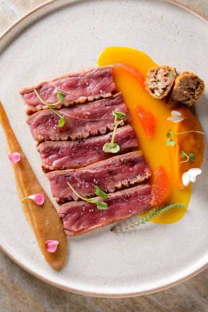 Magret de pato, croquete de coxa confitada, coulis de ervas-laranja e toranja com purê de abóbora e purê de maçã