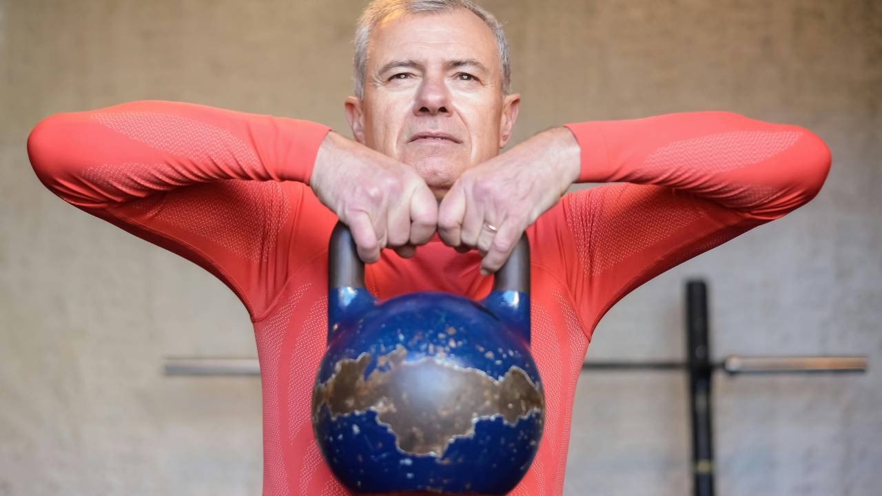 Homem idoso realizando musculação.