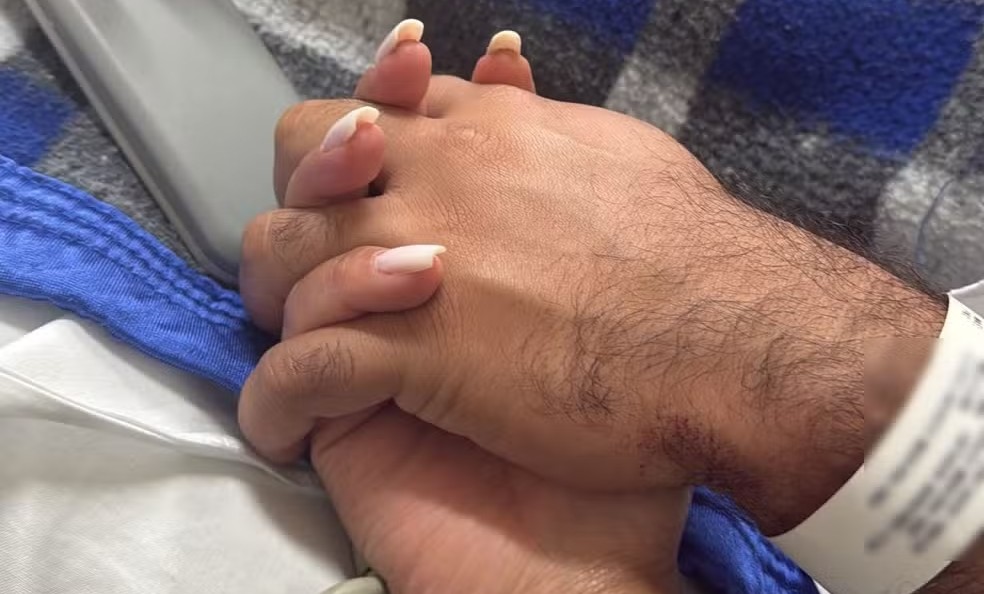 Internado: Poliana, a esposa, postou foto segurando a mão do marido baleado, após cirurgia