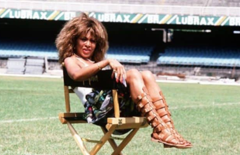 8 Mulher negra (cantora Tina Turner) sentada em cadeira no meio do gramado do campo de futebol do Estádio do Maracanã