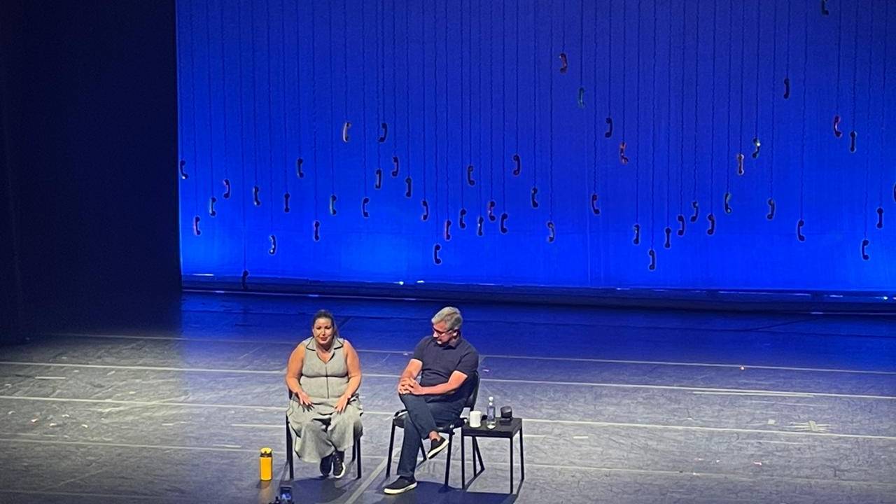 Foto de Mariana Xavier e Fabio Barbirato no palco do teatro.