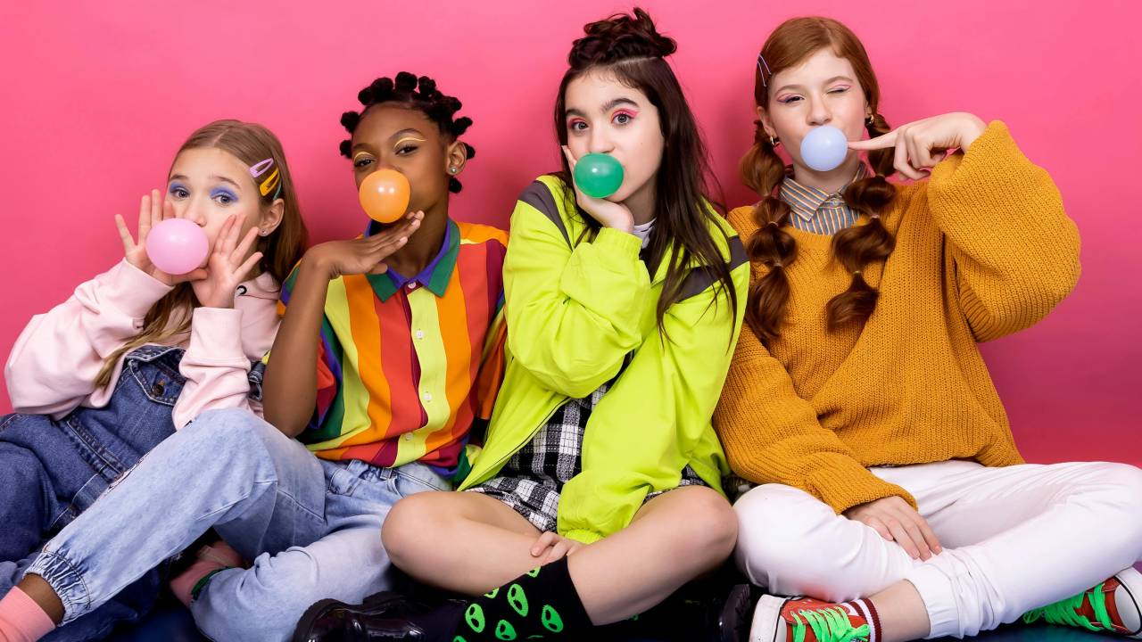Meninas com bolas de chiclete na boca