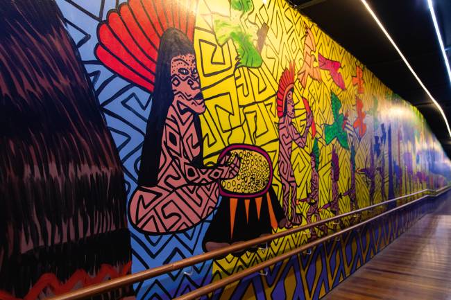 Obra 1_NossaVidaBantu_CrisLucena_Baixa41.JPG Via de acesso: corredores da exposição foram pintados por coletivo indígena