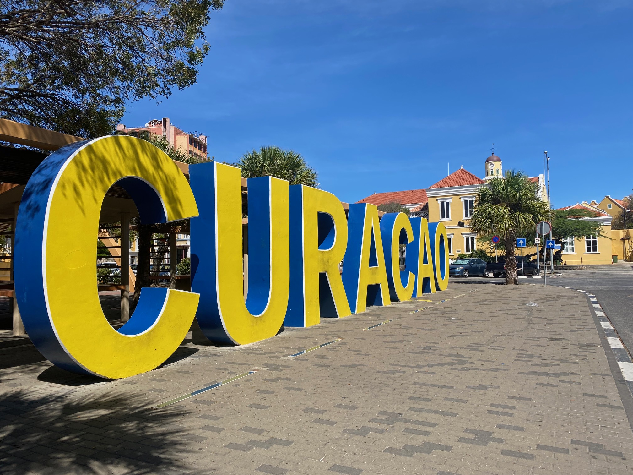 A imagem mostra tótem com a palavra Curaçao exposta no centro da ilha caribenha
