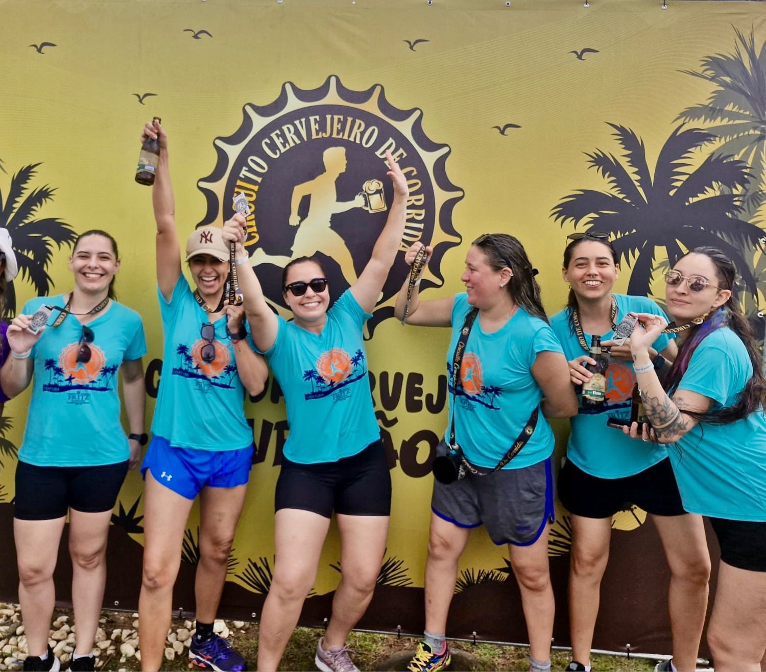 Seis mulheres sorridentes, vestindo camisetas azuis do 