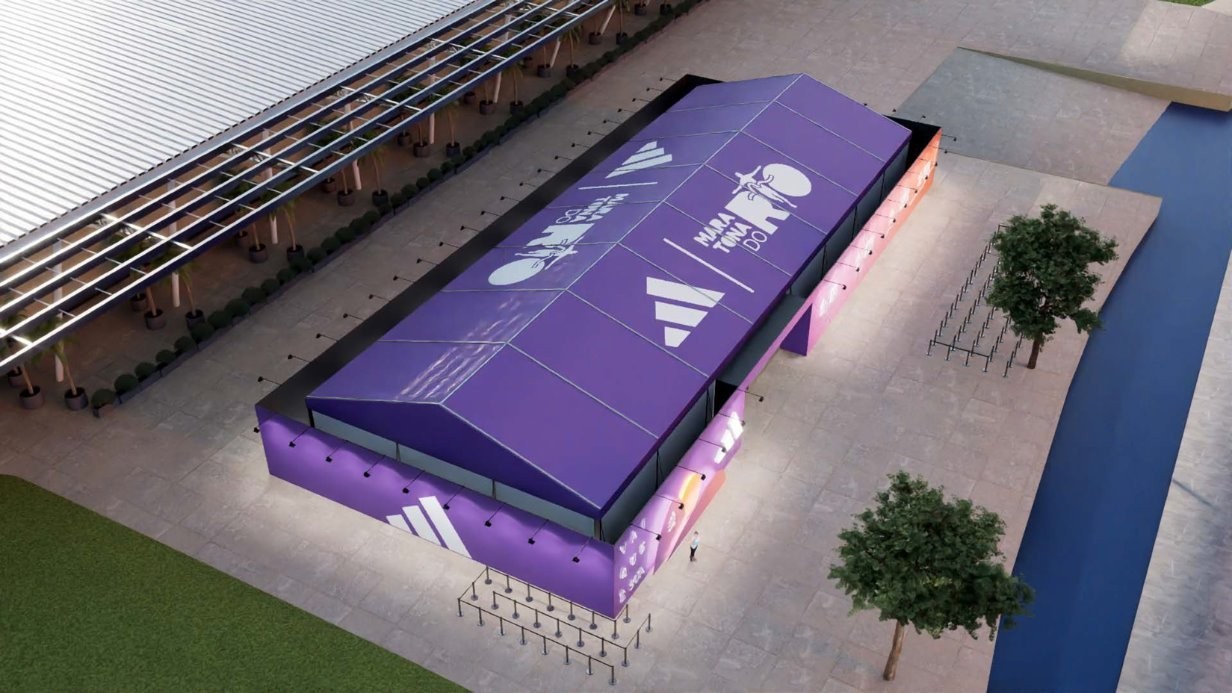 Vista aérea de um grande pavilhão roxo com logotipos brancos da Adidas e 