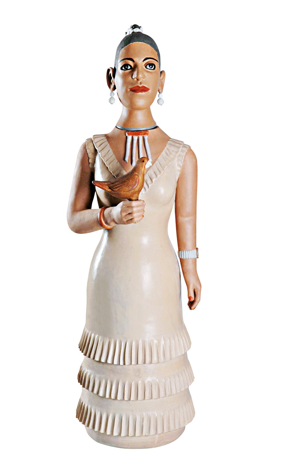 Escultura de mulher com pele escura, cabelo preso, brincos de pérola e colar tribal. Veste um vestido bege com babados na saia e segura um pássaro marrom na mão direita