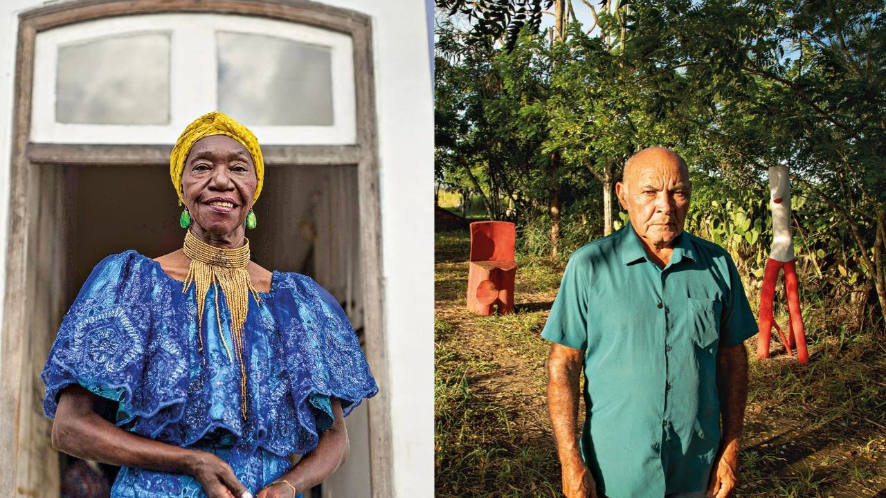 Mulher negra sorrindo, com turbante amarelo, brincos verdes e colar dourado, em frente a uma janela branca. Ao lado, homem pardo sério, de camisa verde, em um jardim com árvores e esculturas vermelhas