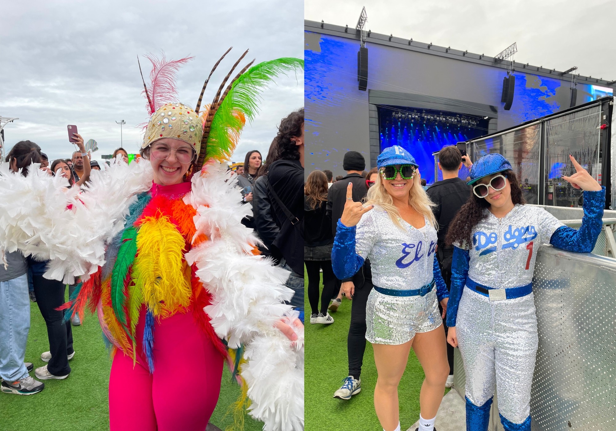 Duas mulheres sorridentes em um festival. À esquerda, uma mulher vestindo fantasia de pássaro com penas coloridas e um chapéu adornado. À direita, duas mulheres loiras com bonés azuis, óculos escuros e roupas prateadas brilhantes, fazendo o sinal de chifre com as mãos, em frente a um palco com iluminação azul