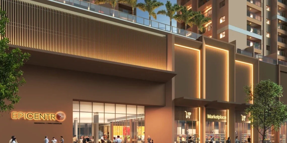 Fachada moderna de um edifício comercial com lojas e apartamentos. À esquerda, a entrada principal com o letreiro EPICENTRO em laranja. À direita, lojas com vitrines iluminadas e o nome Marketplace. Pessoas transitam na calçada, e palmeiras decoram o topo do prédio.